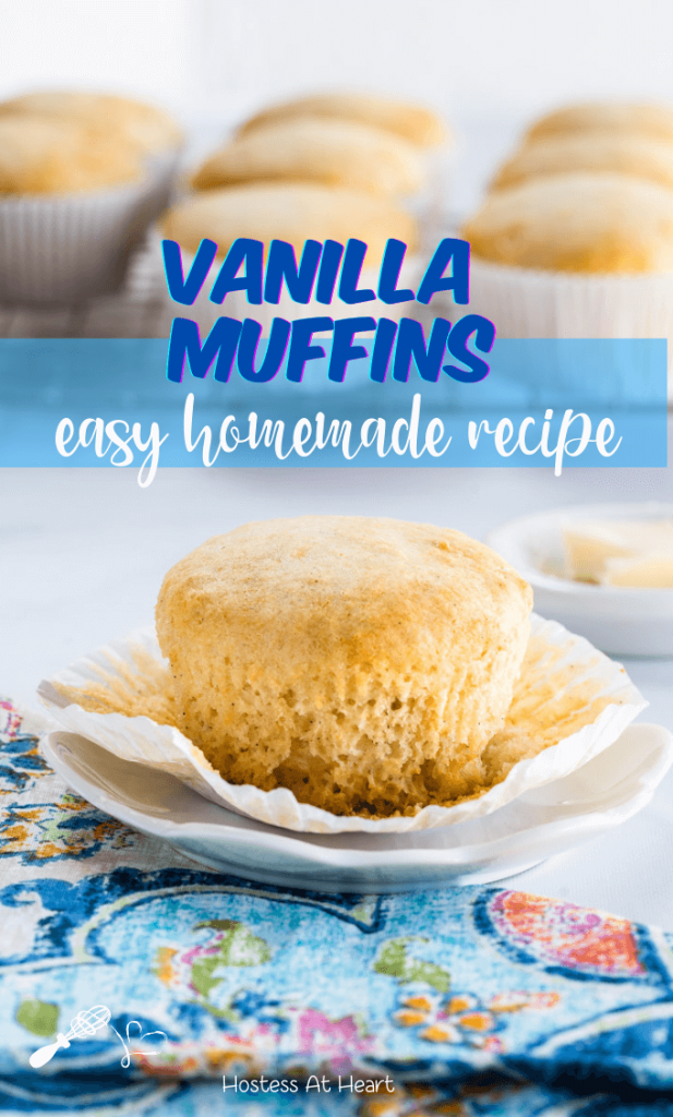 Side view of a Vanilla Muffin sitting on a white plate over a multi-colored napkin. A cooling rack filled with baked muffins sit in the background.