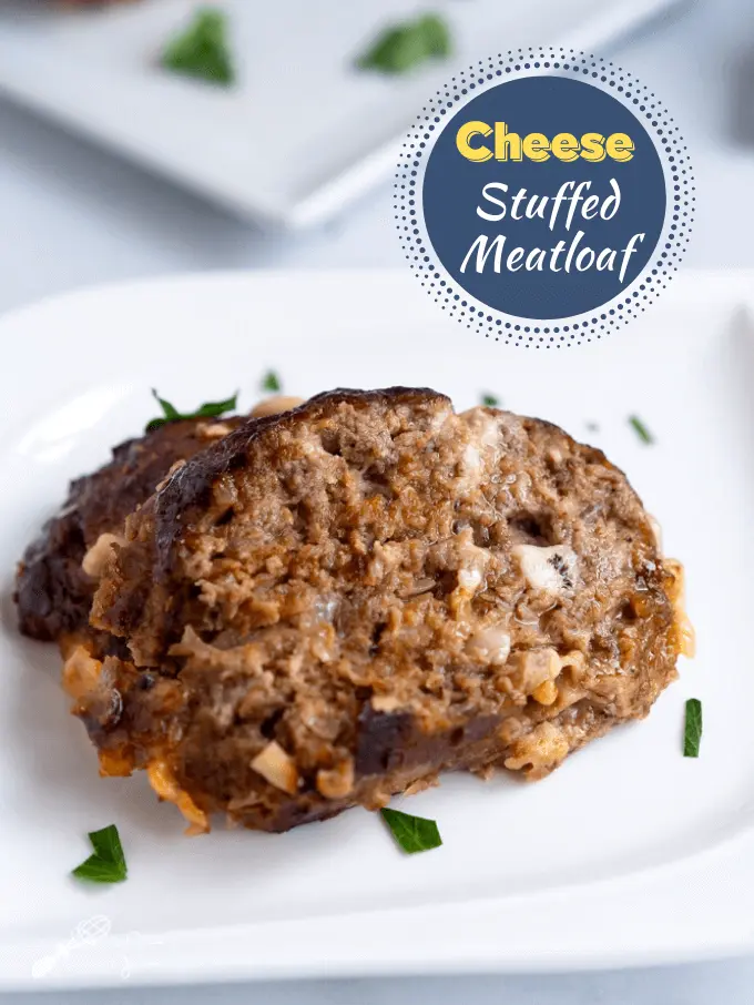 Top down photo of cheese stuffed meatloaf garnished with fresh parsley on a white plate.