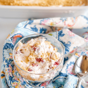 Top down view of a glass dish filled with a Strawberry Cheesecake Salad that's been garnished with graham cracker crumbs.