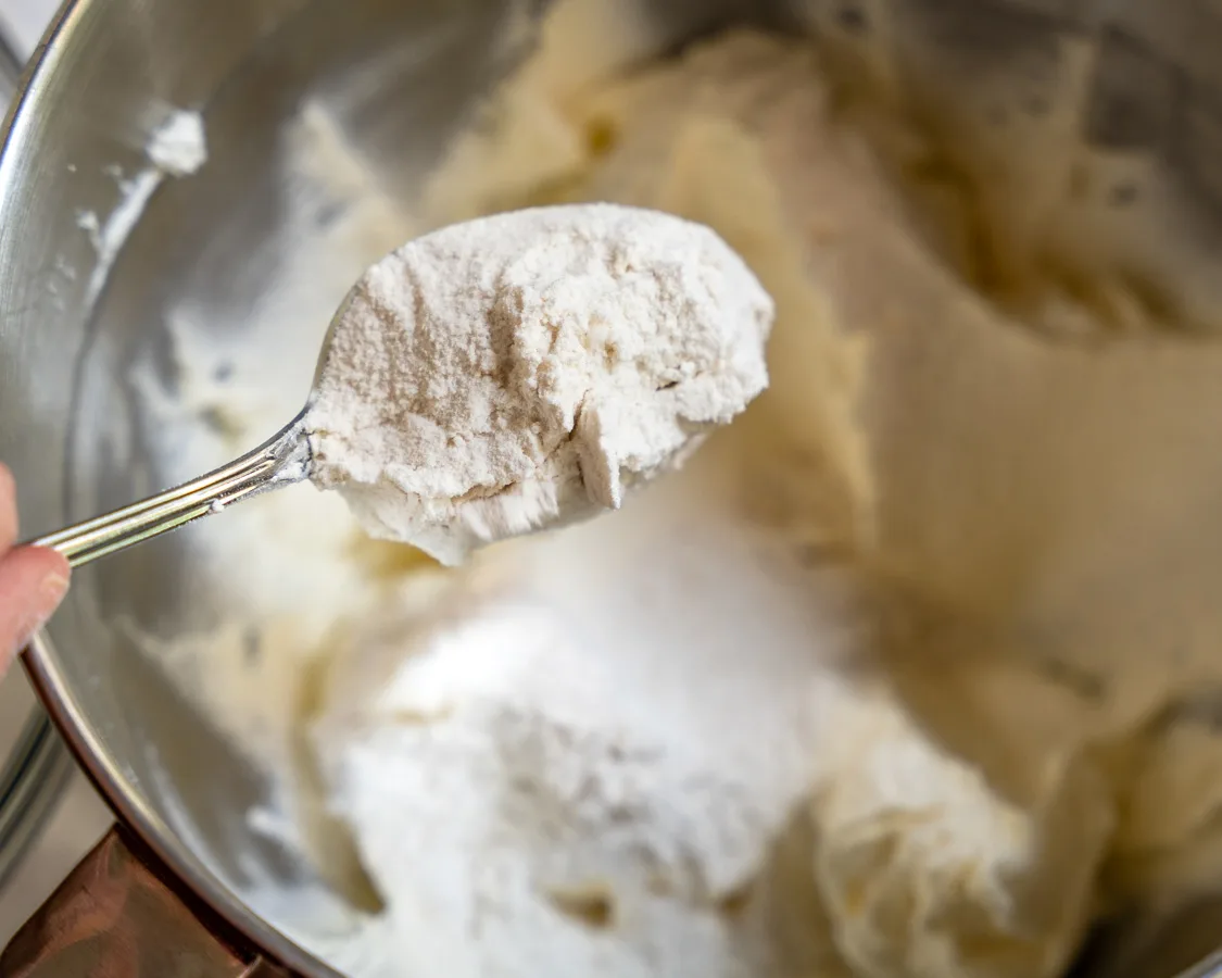 Adding flour to creamy cookie dough - hostess at heart