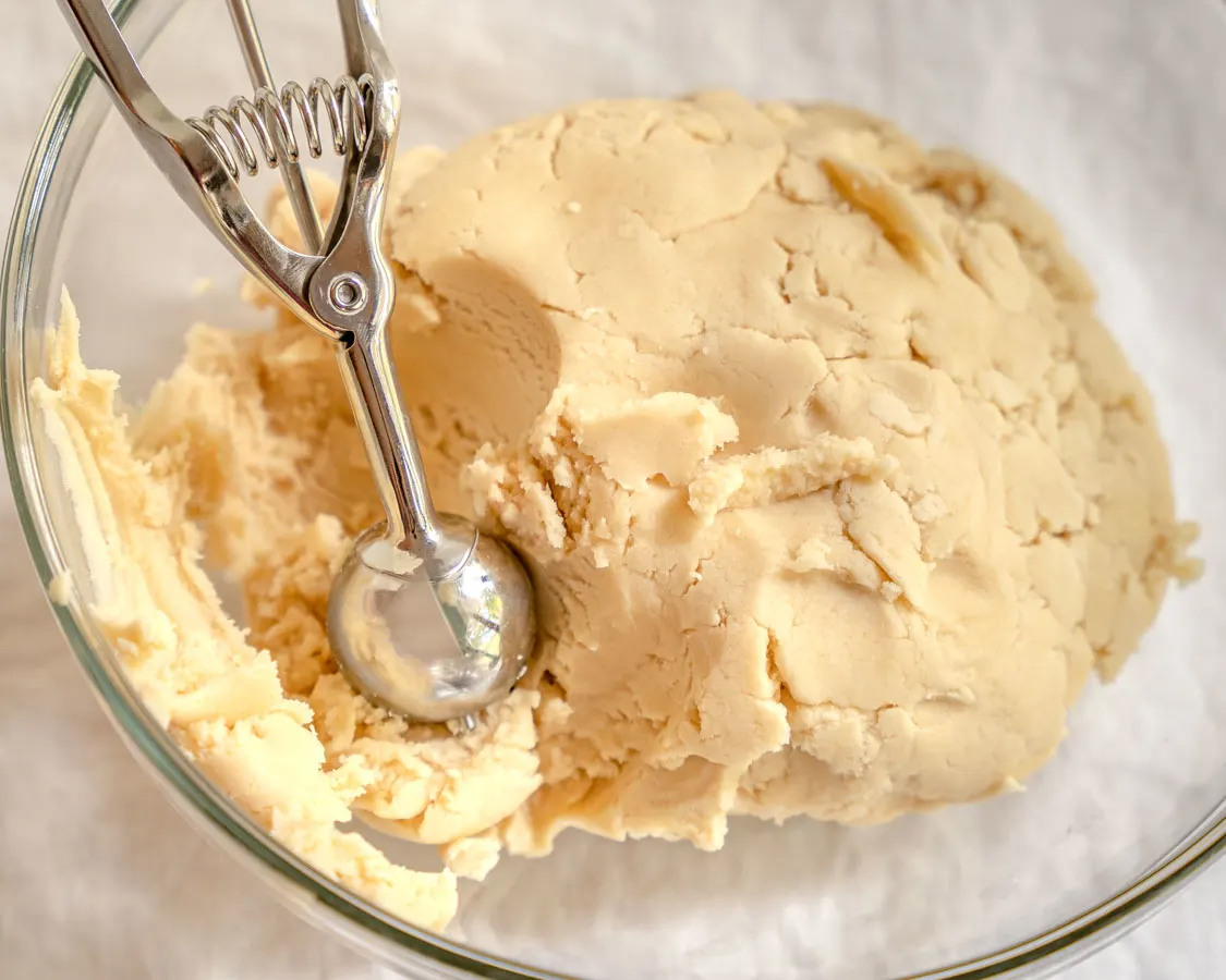 Cookie dough with a cookie scoop in a bowl - hostess at heart