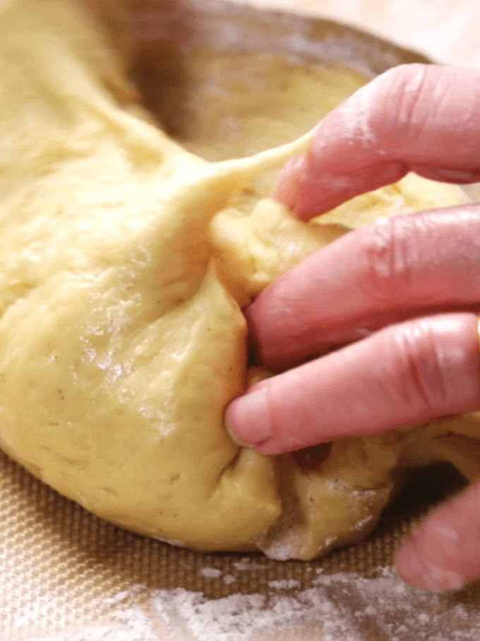 Photo of a hand kneading dough.