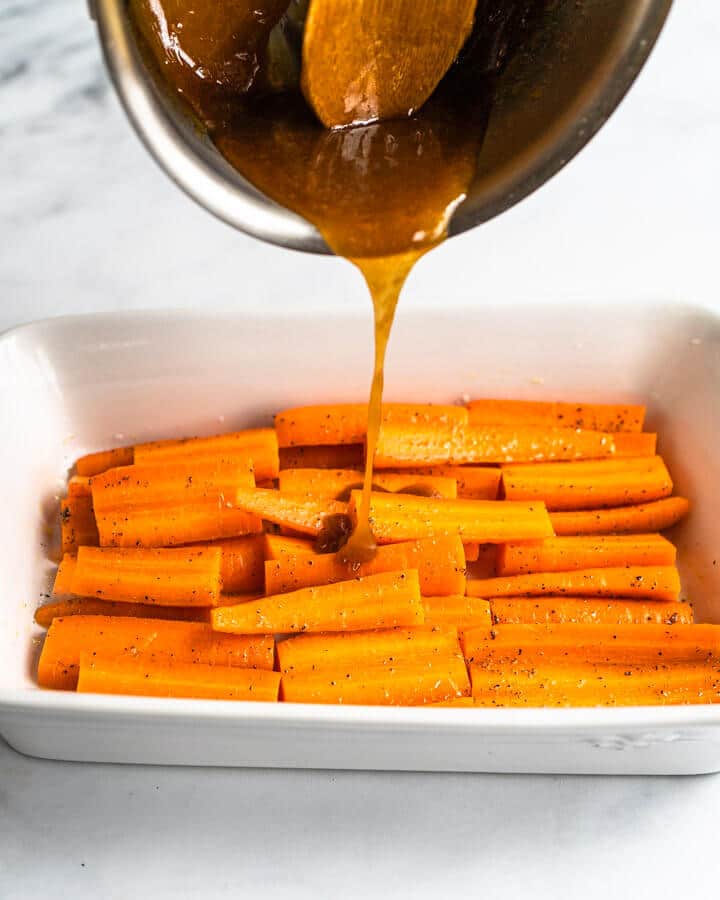 Sliced carrots drizzled with brown sugar and orange glaze before roasting - Hostess At Heart