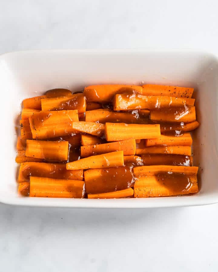 Sliced carrots tossed with brown sugar and orange glaze before roasting - Hostess At Heart