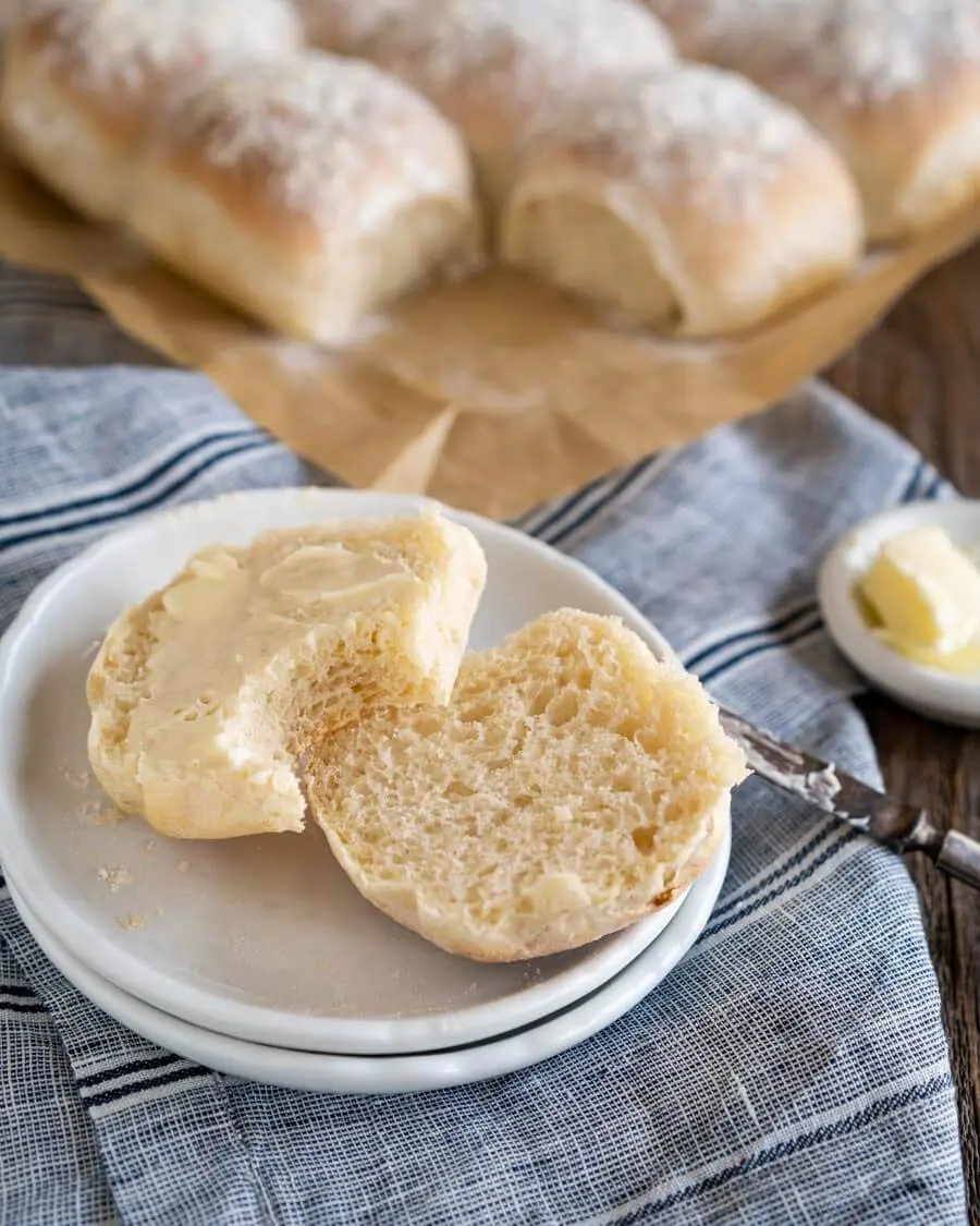 3/4 angle of a roll cut in half, buttered and with a bite taken out of it.