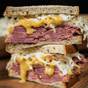 Corned Beef sandwich overloaded with sliced corned beef, mustard sauce and a cabbage slaw.