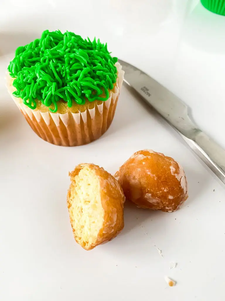 A donut hole cut in half to make the bunny's butt and a cupcake piped with grass. 