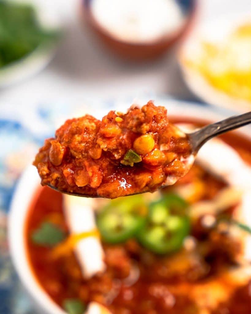 A spoon heaped with lentil chili