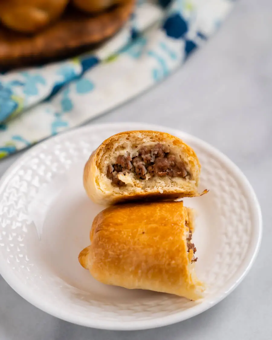 A bread roll cut in half showing cooked meat filling.