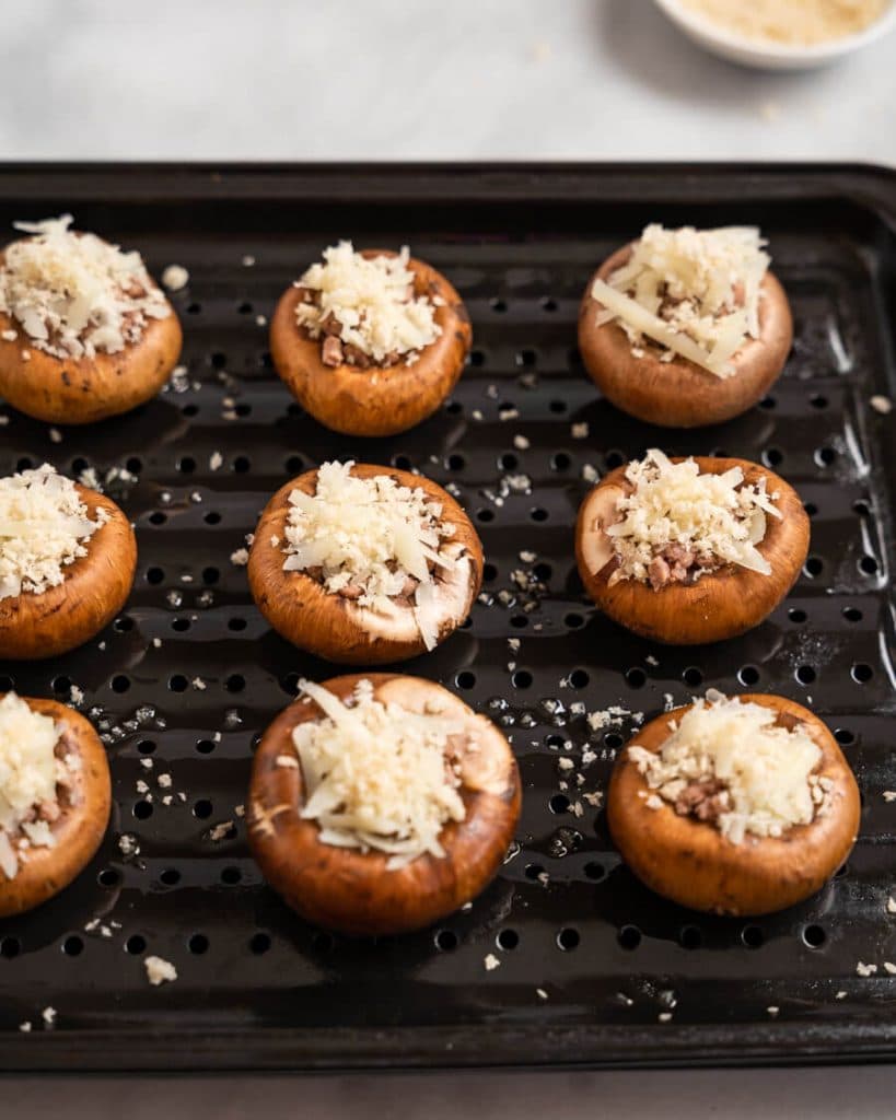 Stuffed mushrooms sitting on a broiler pan.