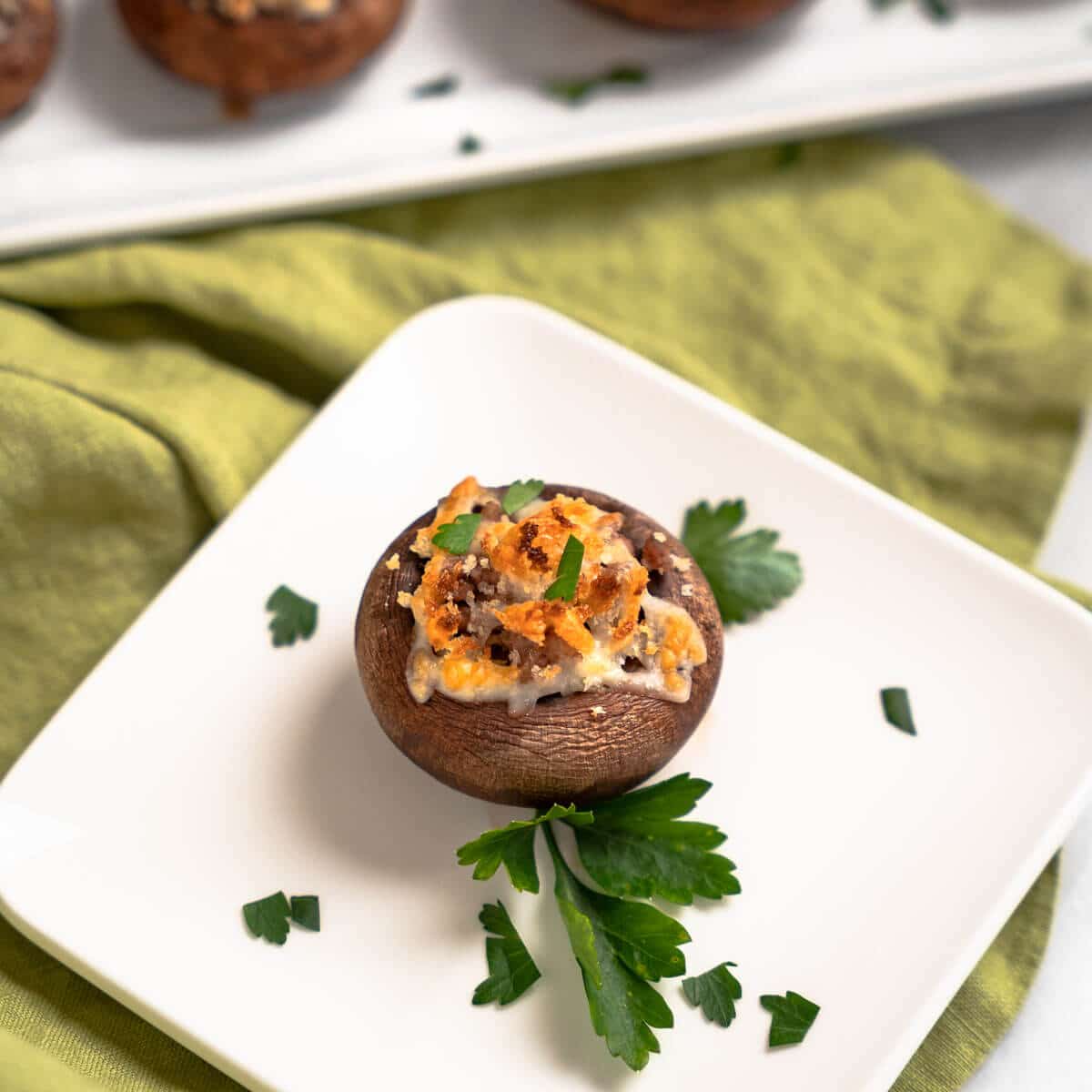 A mushroom stuffed with meat and cheese on a white plate