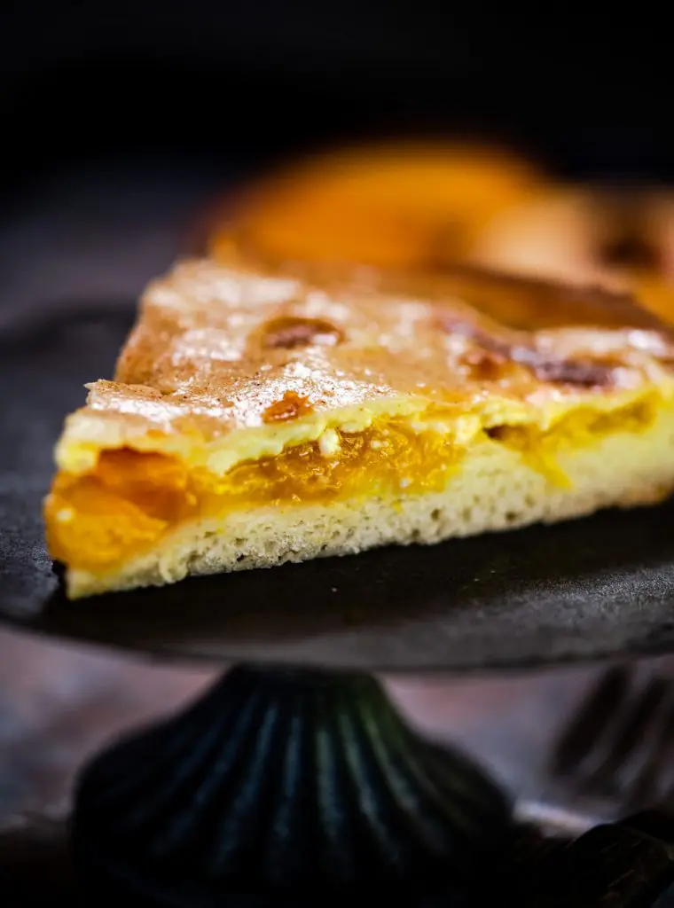 Tableview of a wedge of peach kuchen.