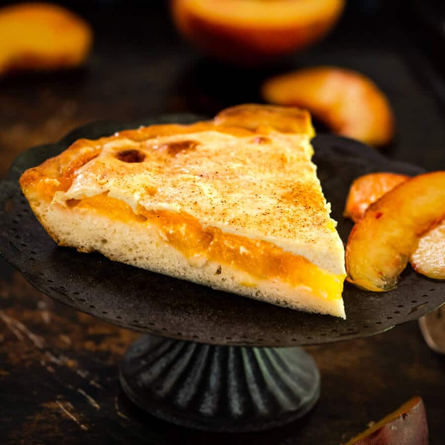 Tableview of a wedge of Peach Kuchen Dessert.