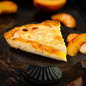 A wedge of dessert with layers of peaches