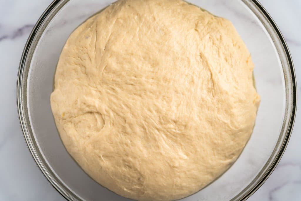 Risen bread dough in a glass bowl