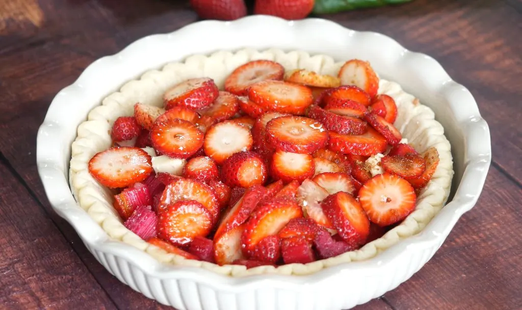 A pie crust filled with a strawberry and rhubarb filling