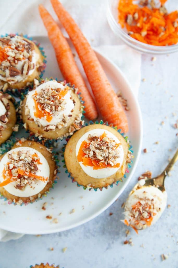 cupcakes recipe presented on a platter with frosting and grated carrots. 