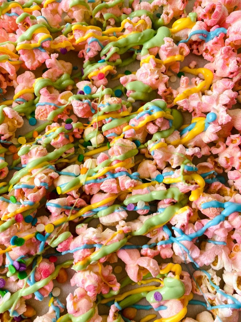 tray of colorful popcorn with candy melt drizzle.