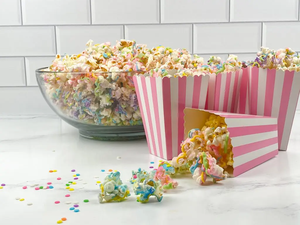 Popcorn boxes filled with multi-colored popcorn with the bowl in the background.