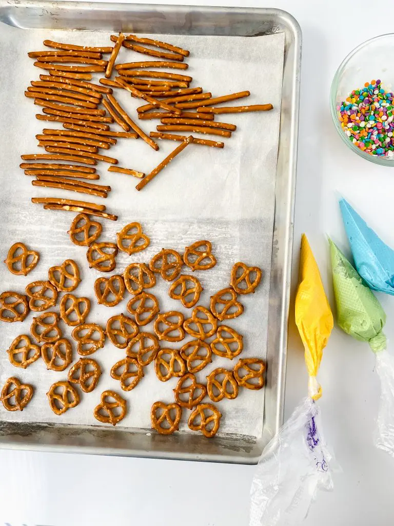 Ingredients to make striped chocolate pretzels and strawberries.