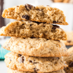 Side view of a stack of chocolate chip cookies with the top cookie broken in half