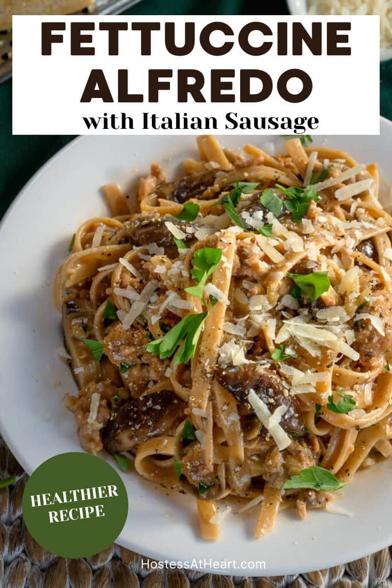 Top down view of a white plate of fettuccine with sausage. Hostess At Heart