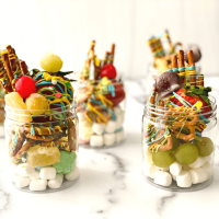 Jars filled with marshmallows, candied grapes, dried fruit, and candied pretzels.
