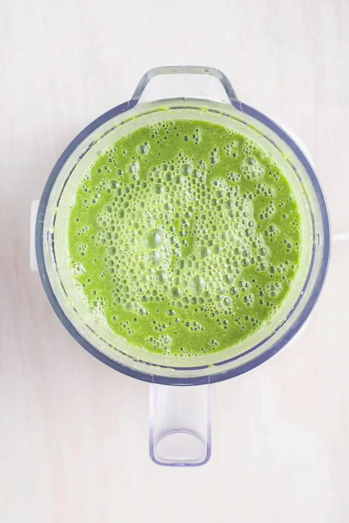 Green smoothie in a blender bowl.