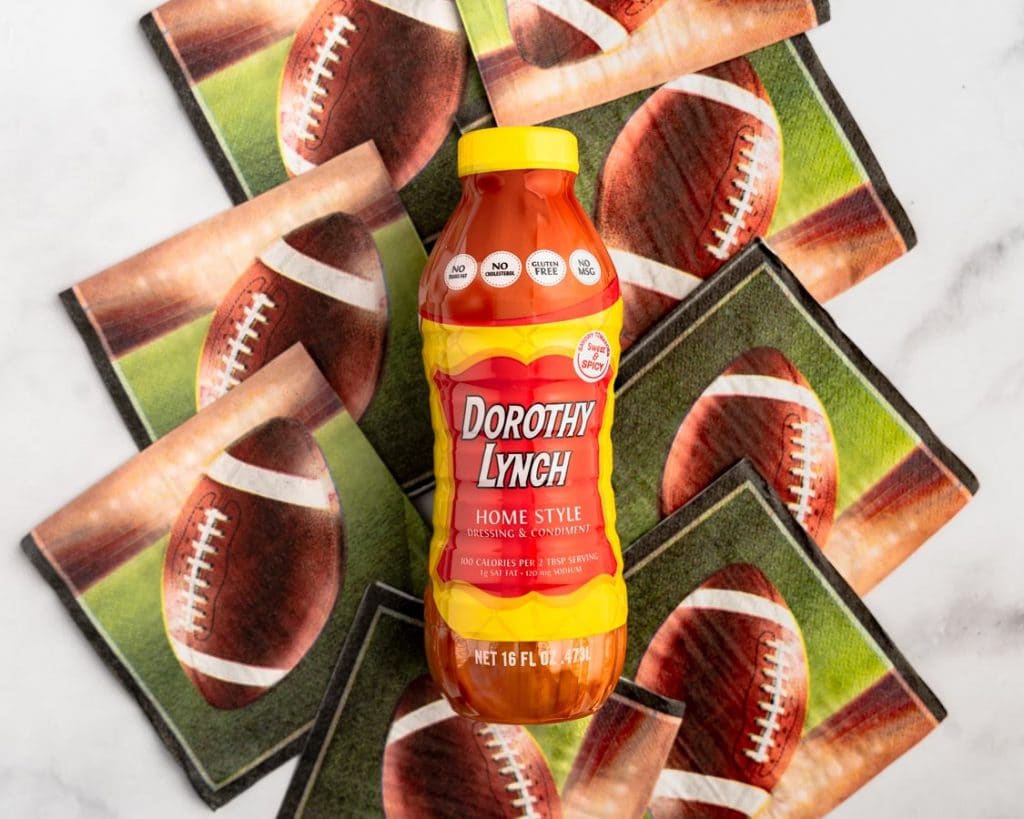 A bottle of Dorothy Lynch Homestyle Dressing & Condiment laying on Football napkins.
