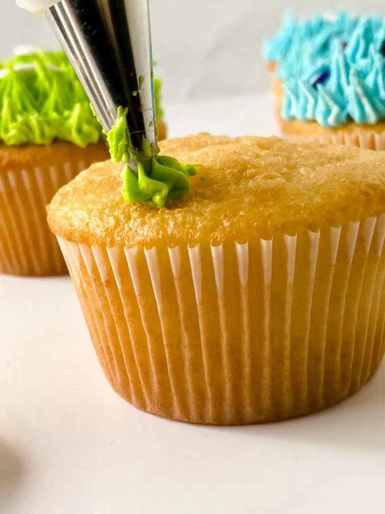 piping with the star tip on a cupcake.