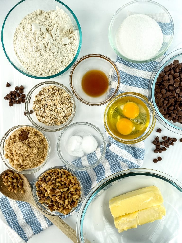 Ingredient shown for recipe: flour, sugar, vanilla, eggs, oats, chocolate chips, butter, walnuts, salt, brown sugar, eggs.