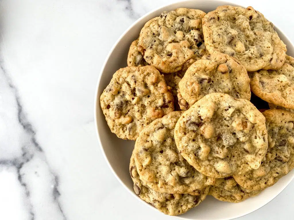 A bowl loaded with baked chocolate chip cookies.