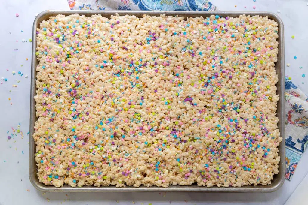 Top down image of a pan of Rice Krispie Treats garnished with colorful sprinkles.