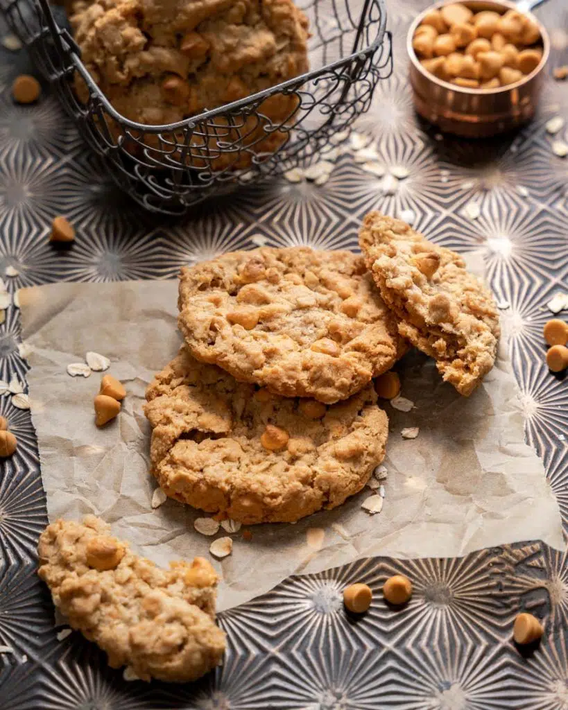 Top down view of two oatmeal butterscotch cookies with a broken cookie leaning against them.