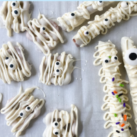 Pretzels drizzled with white chocolate and garnished with candy sprinkles and eyeballs to resemble mummies.