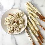 Pretzels drizzled with white chocolate and garnished with candy sprinkles and eyeballs to resemble mummies.