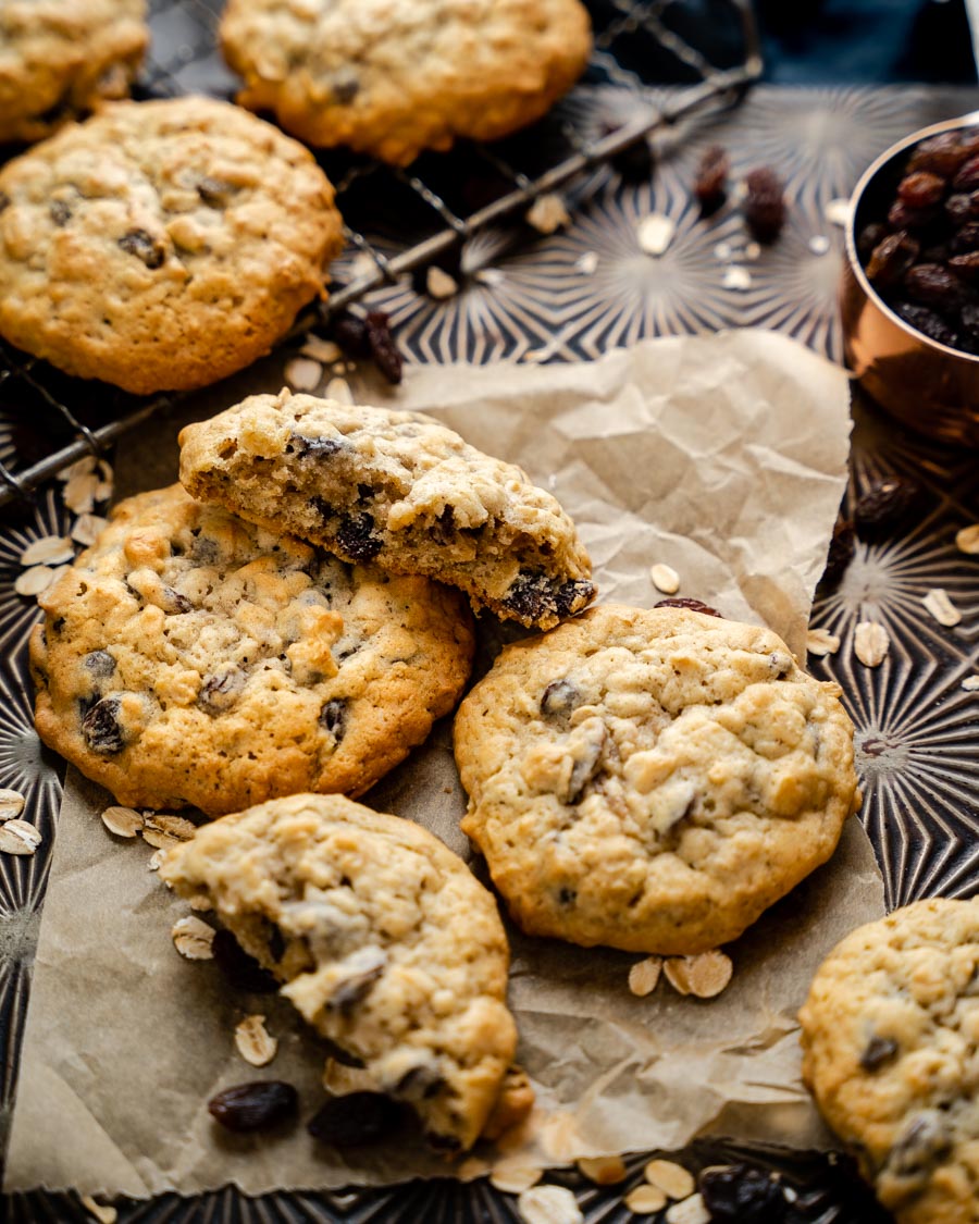 Top down view of Golden Brown Moist oatmeal raisin cookies scattered on a baking sheet - Hostess At Heart