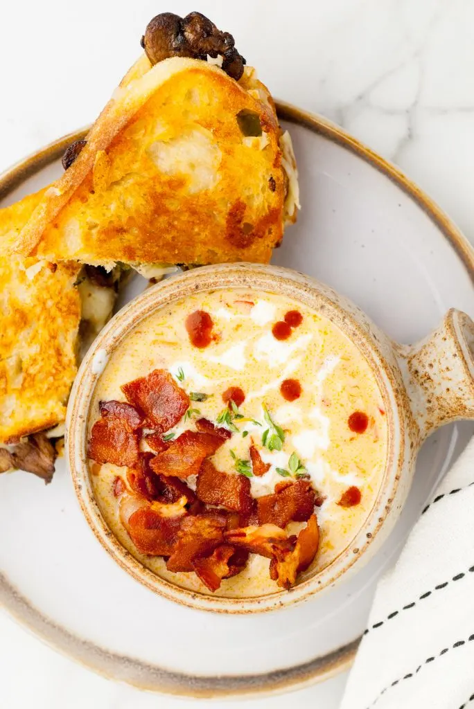 Top-down view of beer cheese soup, sandwiches.