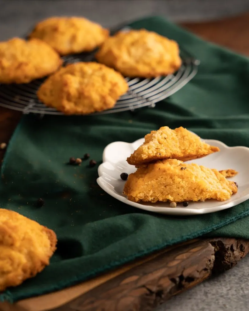 Front view of a cut biscuit showing specks black pepper in the crumb.