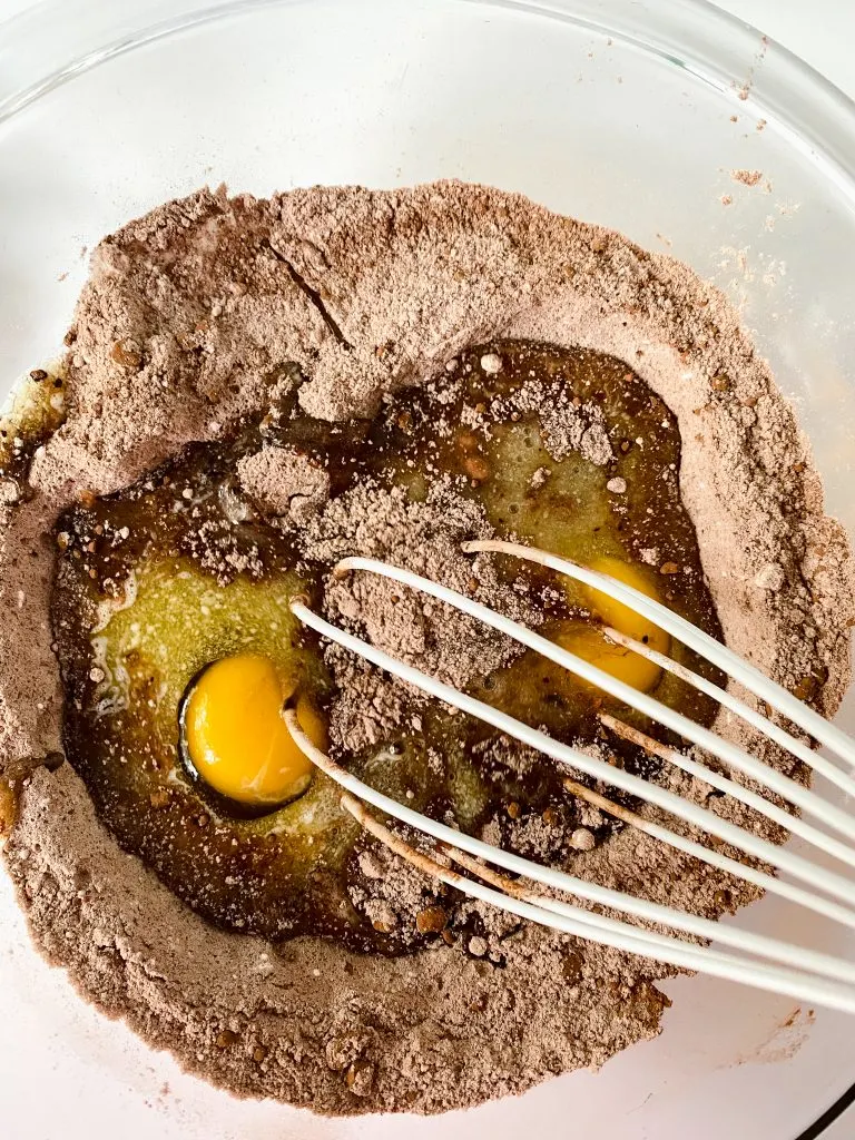 Eggs and butter whisked into brownie dry ingredients.