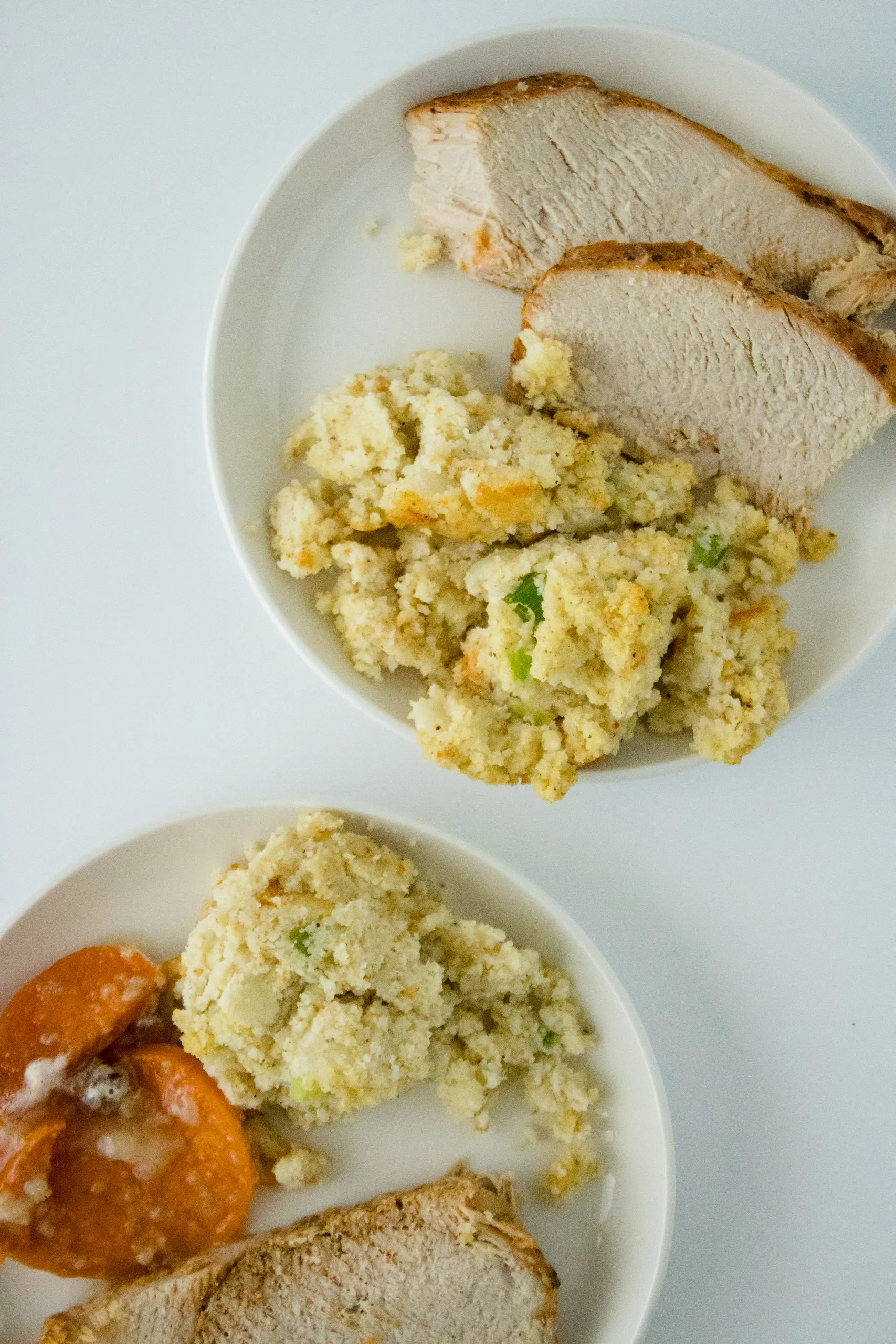 Classic Thanksgiving meal with turkey and cornbread dressing on a plate.