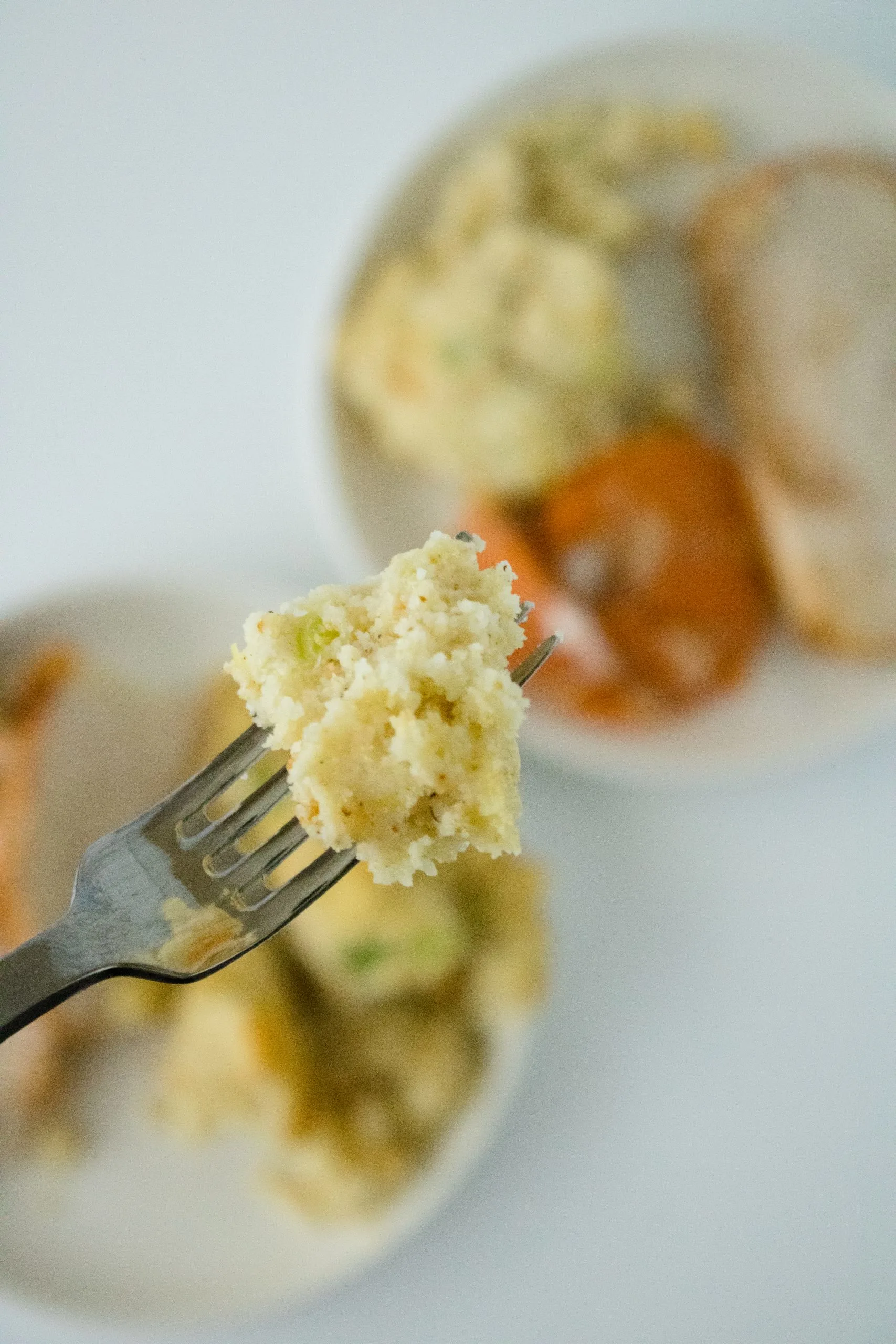 A fork holding a bite of cornbread stuffing.