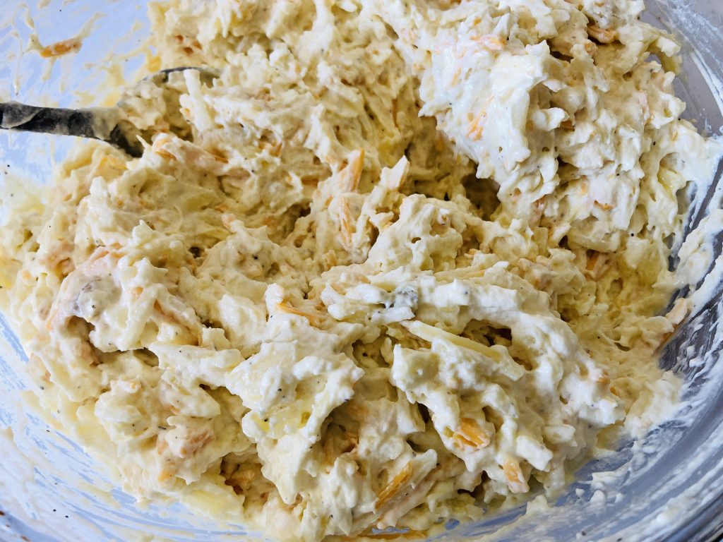 Mixed hash brown casserole ingredients in a bowl