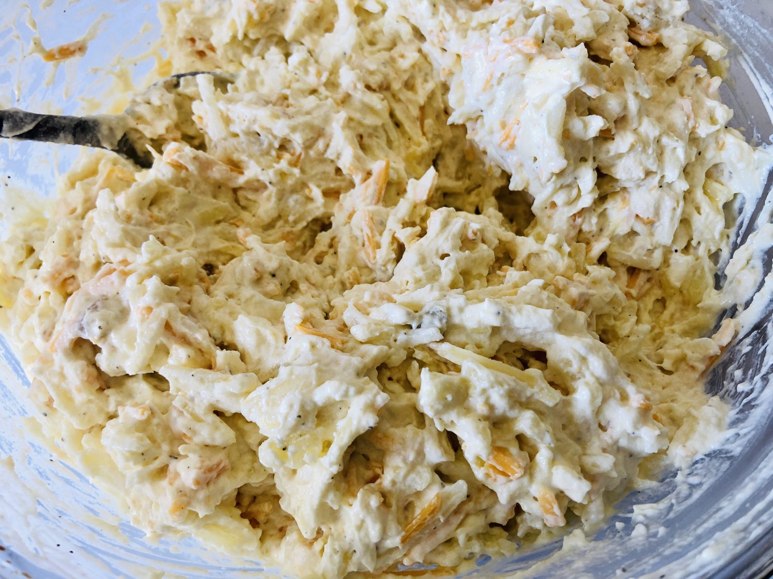 Mixed hash brown casserole ingredients in a bowl