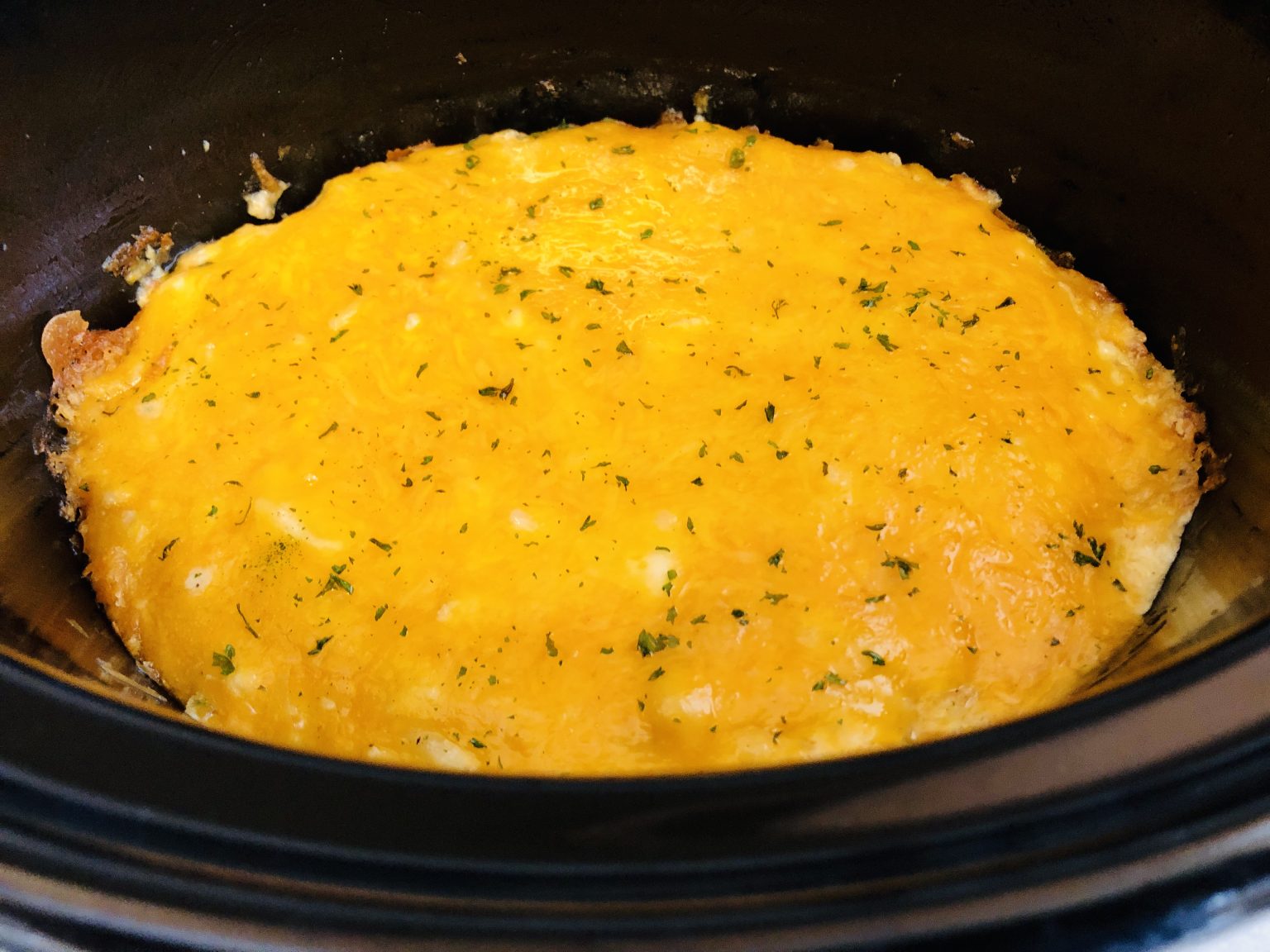 Melted cheese over a crockpot casserole.