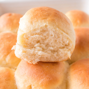 A dinner roll sitting on a pan of dinner rolls