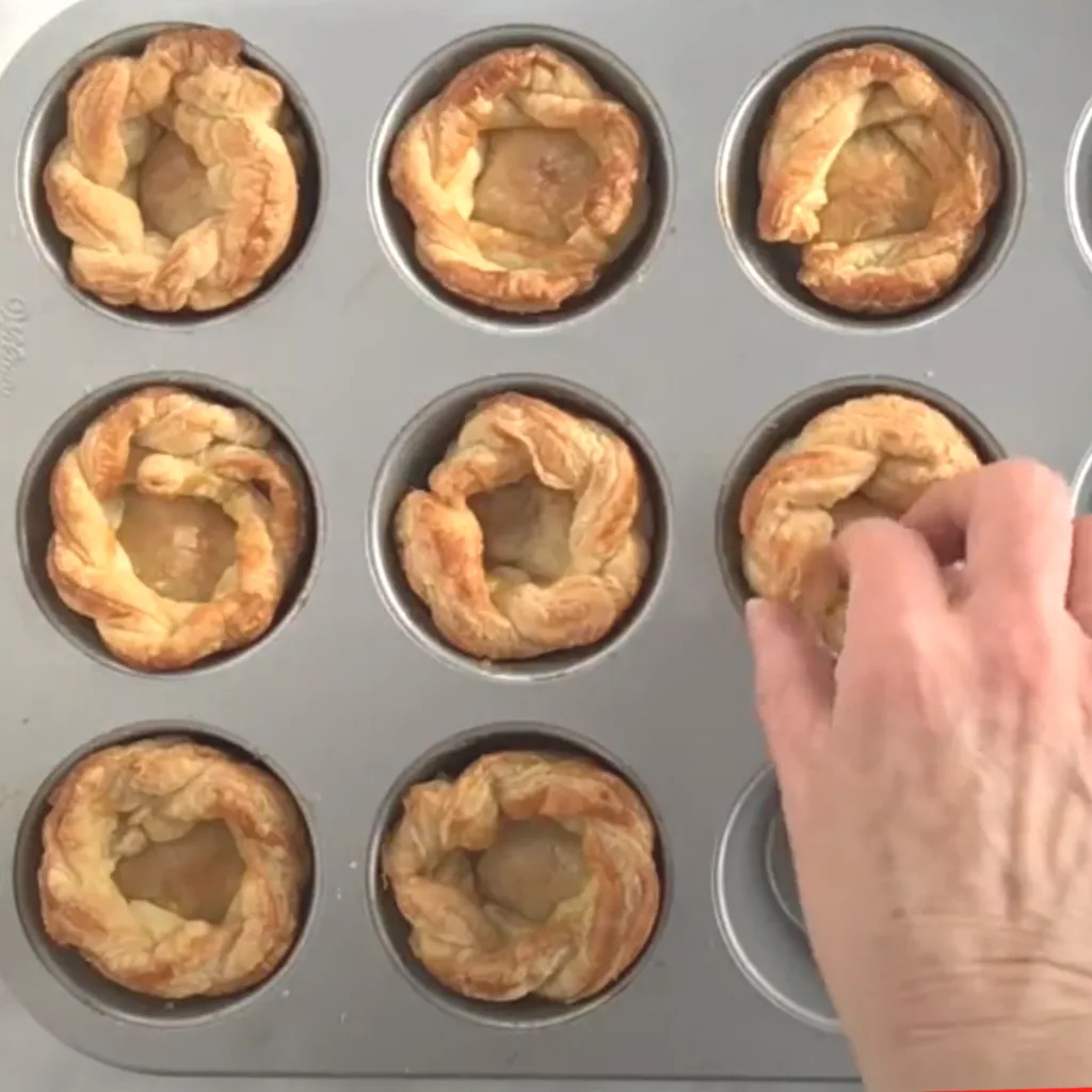 Muffin tin filled with baked puff pastry cups