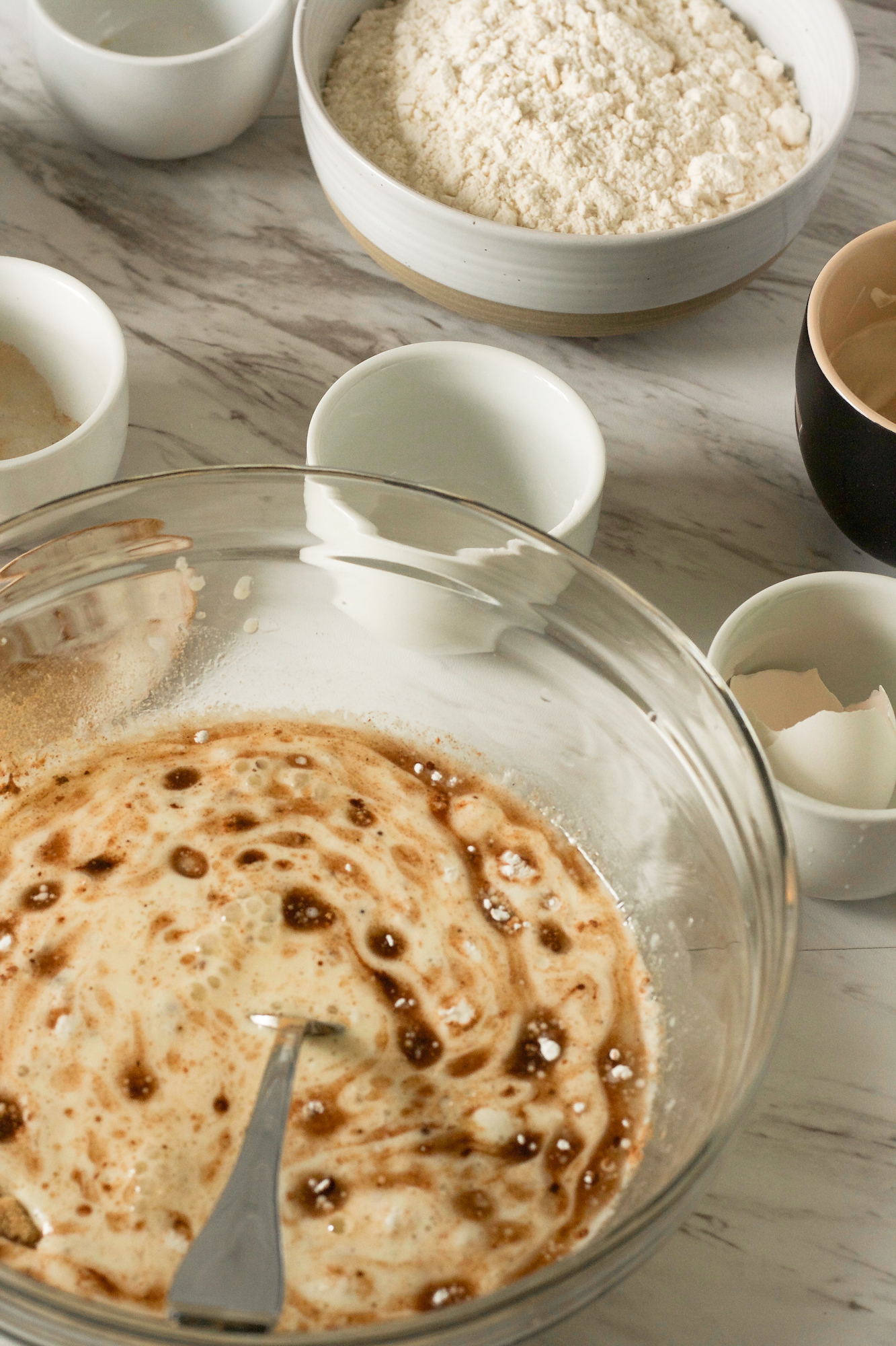 A large mixing bowl filled with sourdough starter, oil, water, vanilla extract, egg, and lemon juice - Hostess At Heart