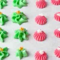 Green and pink cream cheese mints on parchment paper