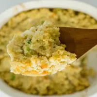 A spoonful of cornbread dressing hovering over a dish.